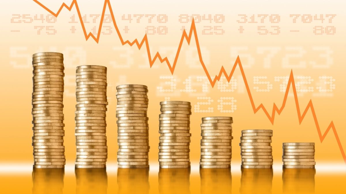 Sette pile di monete dorate di altezza decrescente davanti a una linea arancione in ribasso e valori numerici.